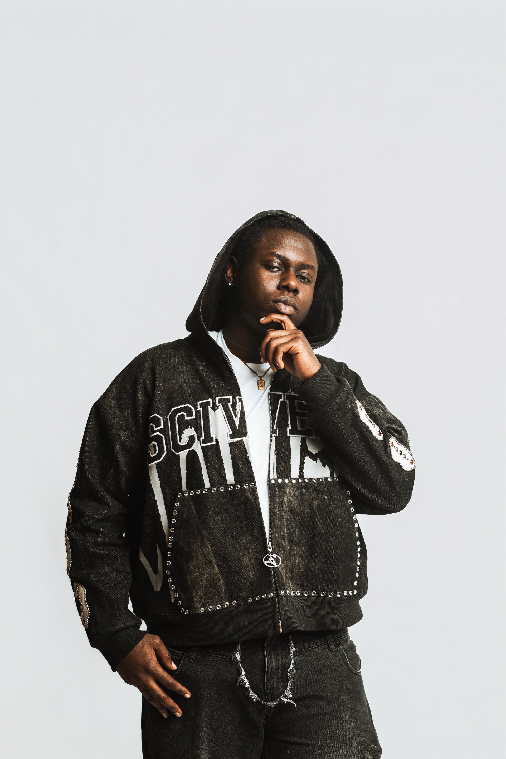 Person wearing a black jacket with white text and graphics on a light gray background